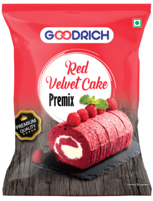 A bowl of rich red velvet cake batter made from Magnum premix, surrounded by decorative red velvet cake slices topped with cream cheese frosting and fresh berries.